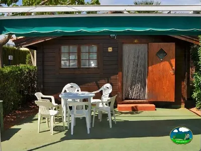 Cabaña de madera con terraza y zona de estar del Camping Bravoplaya, Ribera de cabanes (Castellón)