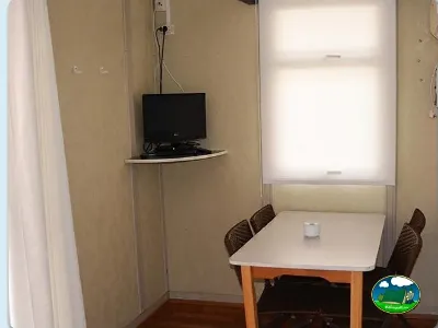 Interior mobil-home con televisor y mesa del Camping Bravoplaya, Ribera de cabanes (Castellón)