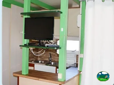 Interior de mobil-home con televisión del Camping Bravoplaya, Ribera de cabanes (Castellón)