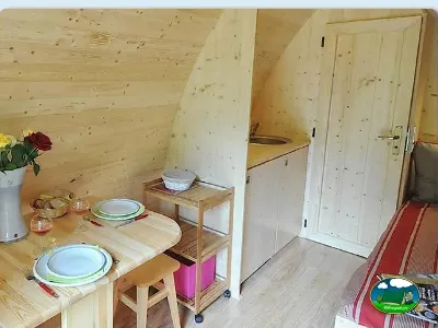 Interior cabaña de madera con mesa comedor y equipamiento del Camping Bravoplaya, Ribera de cabanes (Castellón)