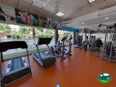 Gimnasio con equipos de fitness y vistas al jardín del Camping Bravoplaya, Ribera de cabanes (Castellón)