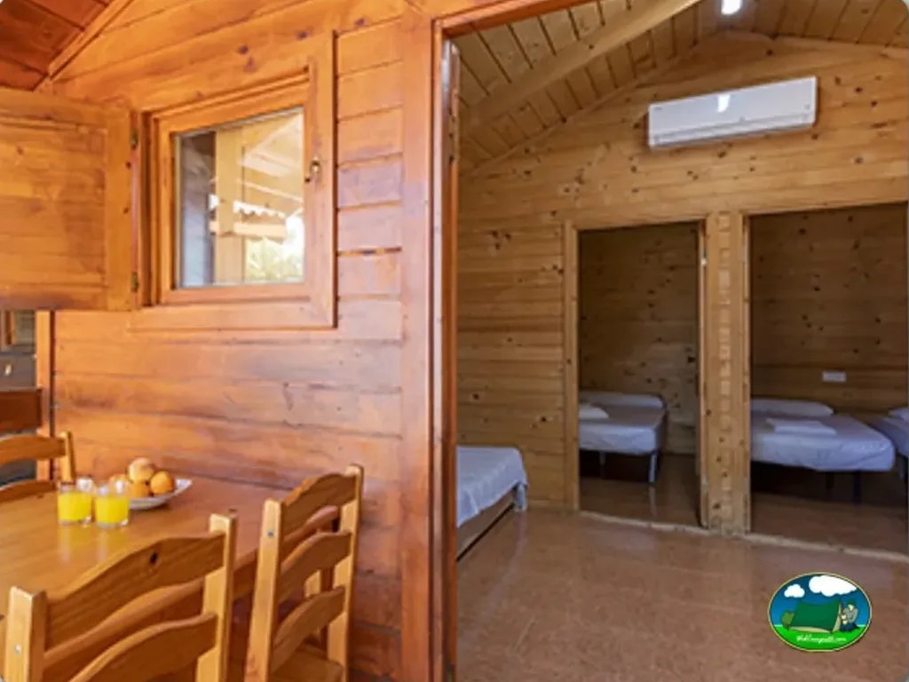 Cabaña de madera con dormitorios y zona de estar del Camping El Cid, Peñiscola (Castellón)