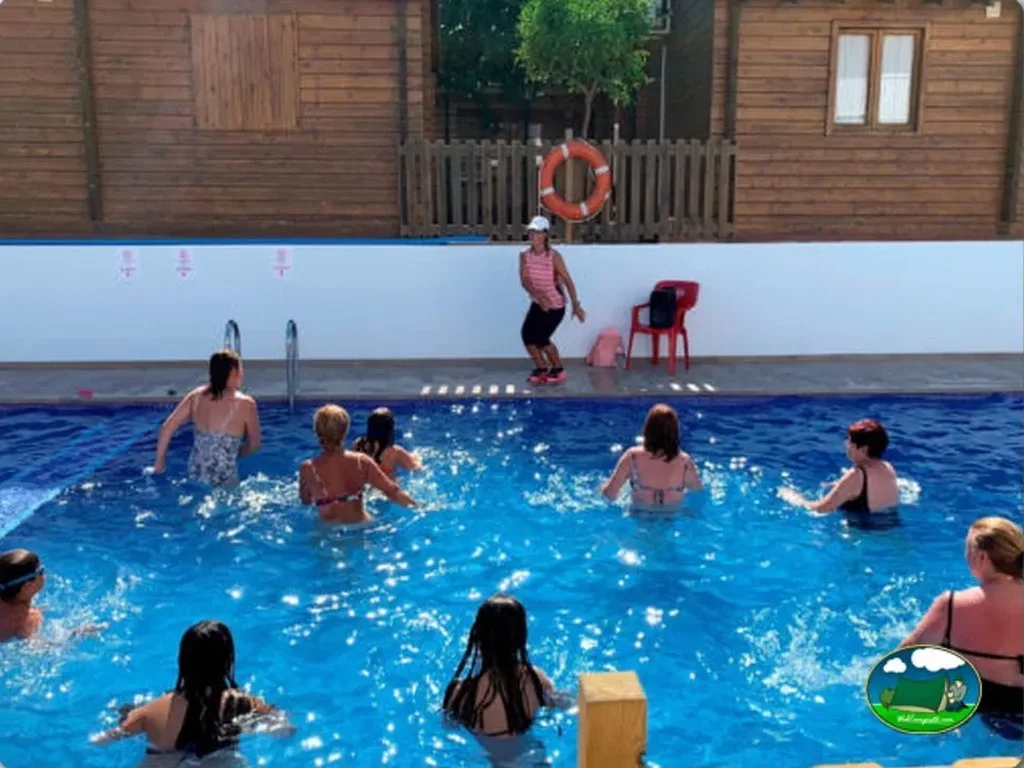 Piscina con niños en clase de natación, bungalow de madera del Camping Ferrer, Peñiscola (Castellón)