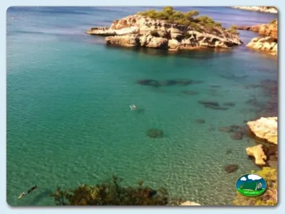Playa junto al mar con aguas cristalinas y rocas del Camping Ampolla Playa, Tarragona (Tarragona)