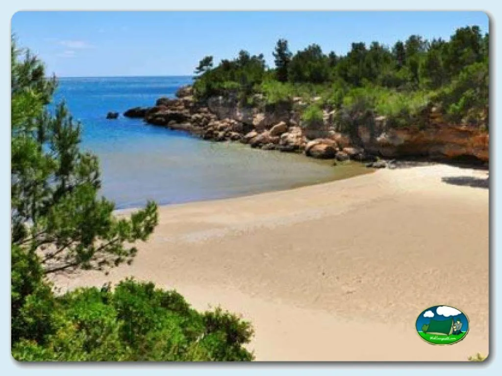 Playa junto al mar con arena blanca y acantilados rocosos del Camping Ametlla, L'Ametlla de Mar (Tarragona)