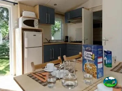 Mobil-home interior con cocina y zona de comedor del Camping La Torre del Sol, Montroig (Tarragona)