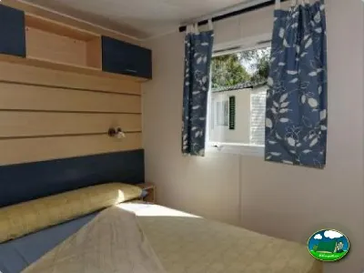 Mobil-home interior con dormitorio y ventana del Camping La Torre del Sol, Montroig (Tarragona)