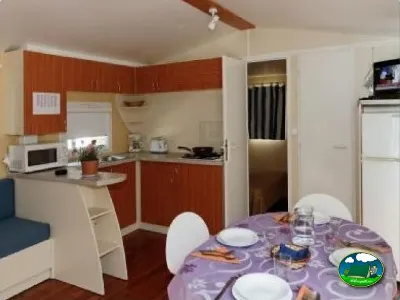 Mobil-home interior con cocina y zona de comedor del Camping La Torre del Sol, Montroig (Tarragona)