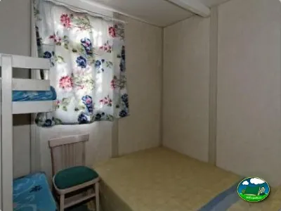 Mobil-home interior con literas y cortinas florales del Camping La Torre del Sol, Montroig (Tarragona)