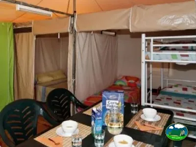 Tienda de acampada con camas literas y zona de comedor del Camping La Torre del Sol, Montroig (Tarragona)