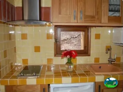 Cocina con encimera de mosaico y muebles de madera del Camping La Torre del Sol, Montroig (Tarragona)