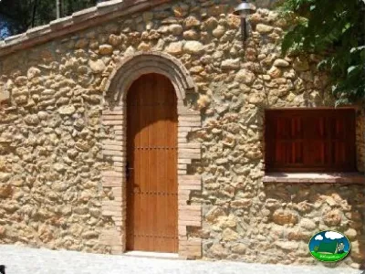 Cabaña de piedra con puerta de madera del Camping La Torre del Sol, Montroig (Tarragona)