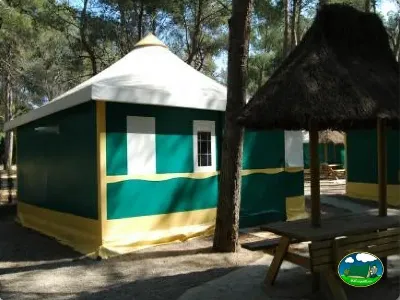 Glamping tipi con diseño turquesa y amarillo entre árboles del Camping La Torre del Sol, Montroig (Tarragona)