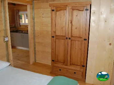 Interior cabaña con armario de madera y kitchenette del Camping La Torre del Sol, Montroig (Tarragona)