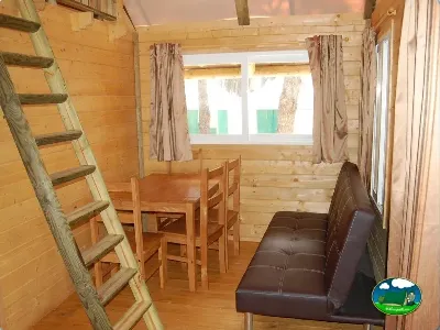 Cabaña interior con mesa de comedor y sofá del Camping La Torre del Sol, Montroig (Tarragona)