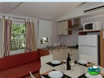 Mobil-home interior con cocina y zona de comedor del Camping La Torre del Sol, Montroig (Tarragona)