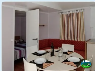 Mobil-home interior con zona de comedor y dormitorio del Camping La Torre del Sol, Montroig (Tarragona)
