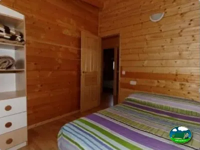 Cabaña interior con paredes de madera y camas del Camping La Torre del Sol, Montroig (Tarragona)