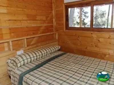 Cabaña de madera con cama doble y vistas a la montaña del Camping La Torre del Sol, Montroig (Tarragona)
