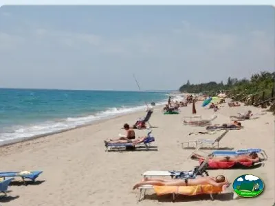 Playa junto al mar con bañistas y hamacas del Camping La Torre del Sol, Montroig (Tarragona)