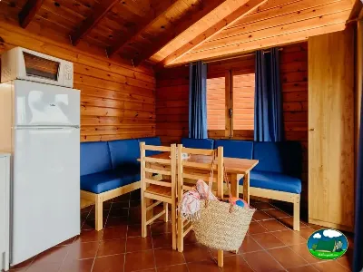 Cabaña interior con cocina, zona de estar y ventanas del Camping La Llosa, Cambrils (Tarragona)