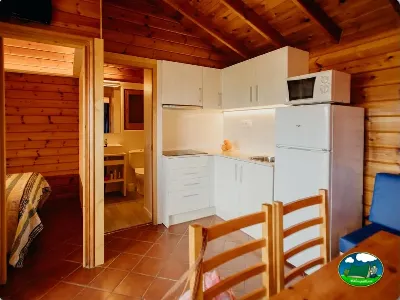 Cabaña de madera con cocina equipada y dormitorio del Camping La Llosa, Cambrils (Tarragona)