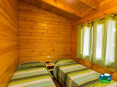 Cabaña de madera interior con dos camas del Camping La Llosa, Cambrils (Tarragona)