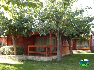 Bungalow rojo con terraza y árboles del Camping La Llosa, Cambrils (Tarragona)